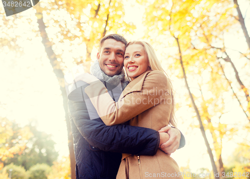 Image of smiling couple hugging in autumn park