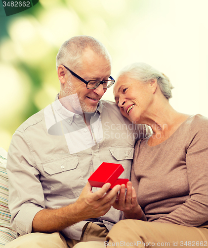 Image of happy senior couple with red gift box