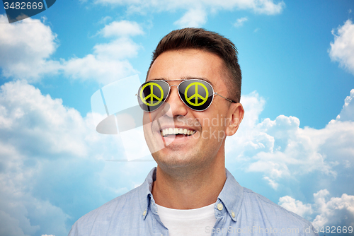 Image of face of smiling man in green peace sunglasses