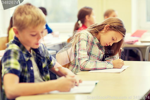 Image of group of school kids writing test in classroom