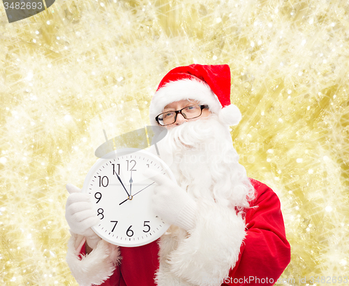 Image of man in costume of santa claus with clock