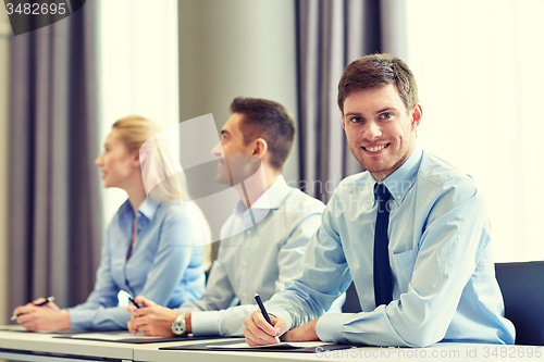 Image of group of smiling businesspeople meeting in office