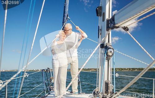 Image of senior couple hugging on sail boat or yacht in sea