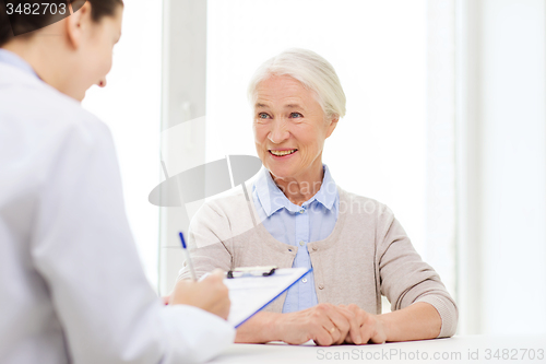 Image of doctor with clipboard and senior woman at hospital