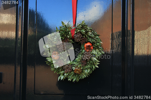 Image of Classic christmas wreath with decorations on a door