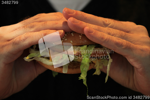 Image of Man holding a hamburger