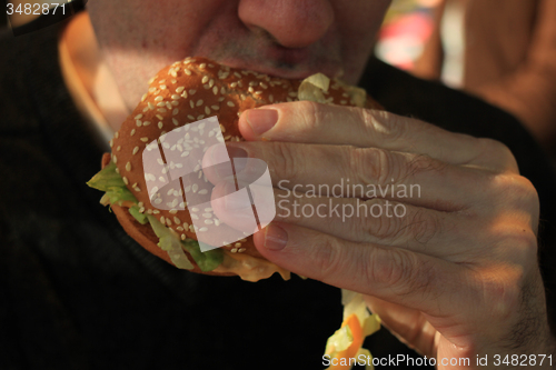 Image of Man holding a hamburger