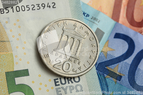 Image of Drachma coin on euro note