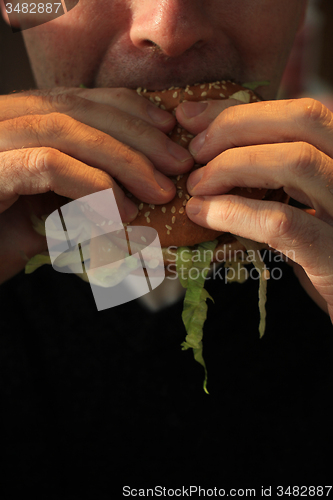 Image of Man holding a hamburger