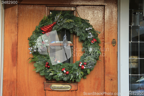 Image of Classic christmas wreath with decorations on a door