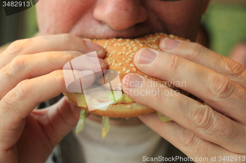 Image of Man eating a hamburger