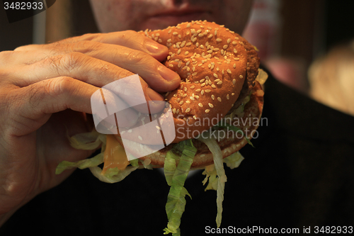 Image of Man holding a hamburger