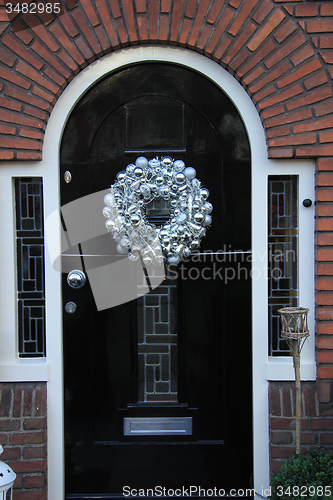 Image of Silver christmas wreath with decorations on a door
