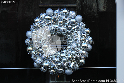 Image of Silver christmas wreath with decorations on a door