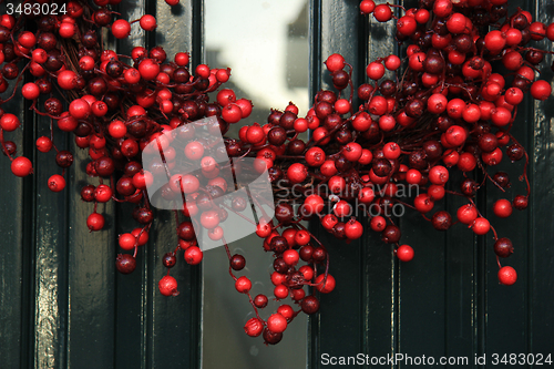 Image of Berry christmas wreath with decorations on a door