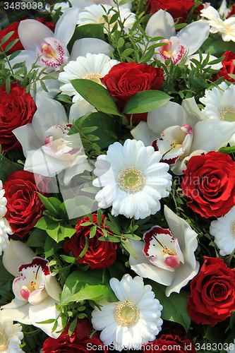 Image of Cymbidium orchids, red roses and white gerberas