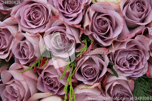 Image of Purple roses in a wedding arrangement