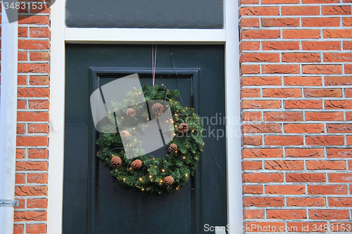 Image of Classic christmas wreath with decorations on a door