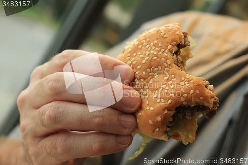 Image of Man holding a hamburger