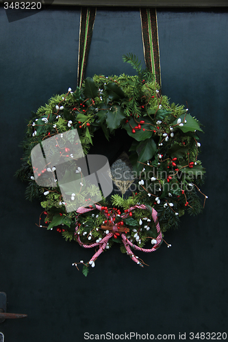 Image of Classic christmas wreath with decorations on a door
