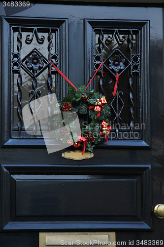 Image of Classic christmas wreath with decorations on a door