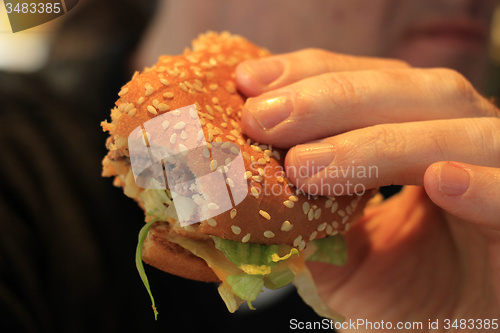 Image of Man holding a hamburger