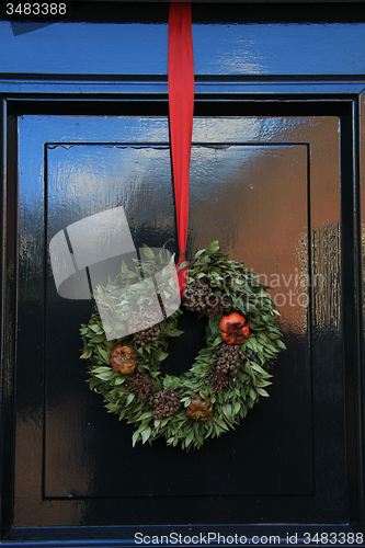 Image of Classic christmas wreath with decorations on a door