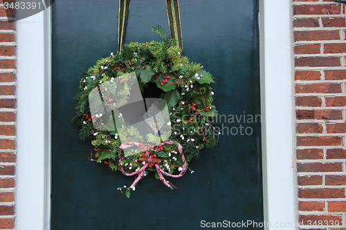 Image of Classic christmas wreath with decorations on a door