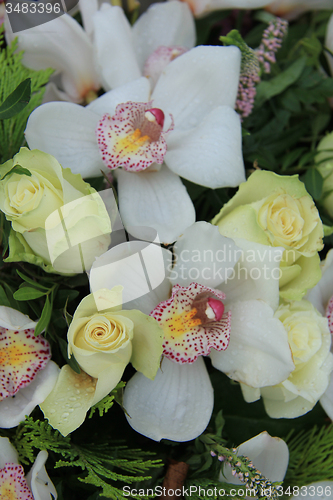 Image of Cymbidium orchids and white roses in bridal bouquet