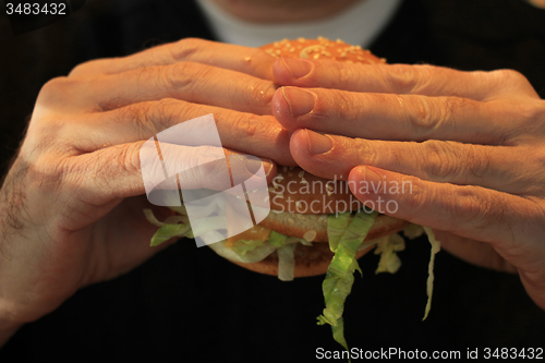 Image of Man holding a hamburger