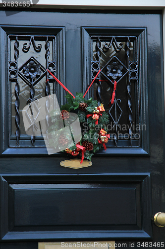 Image of Classic christmas wreath with decorations on a door