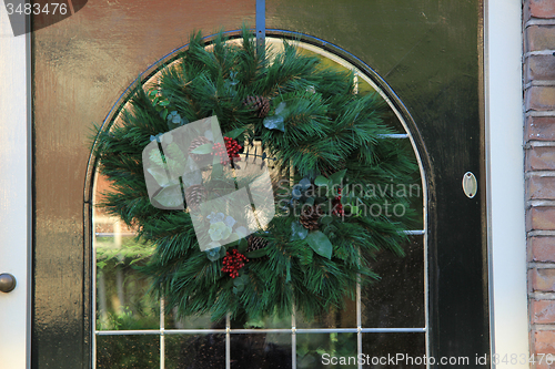 Image of Classic christmas wreath with decorations on a door