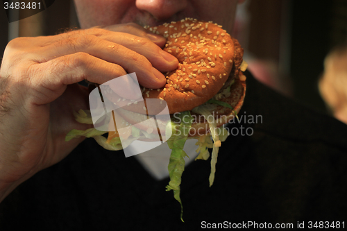 Image of Man holding a hamburger