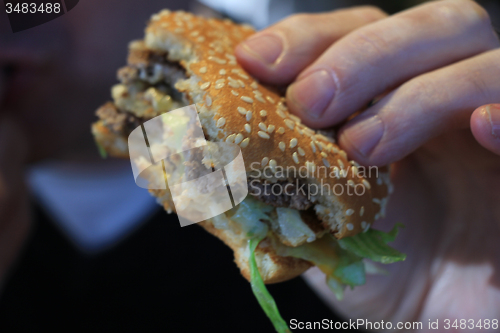 Image of Man holding a hamburger