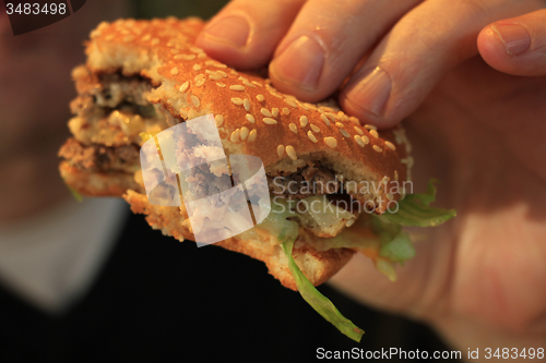 Image of Man holding a hamburger