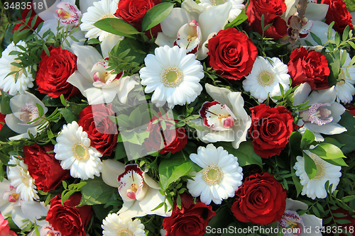 Image of Cymbidium orchids, red roses and white gerberas