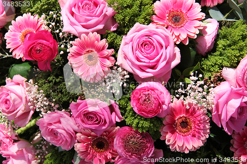 Image of Ranunculus, roses and gerberas in a wedding arrangement