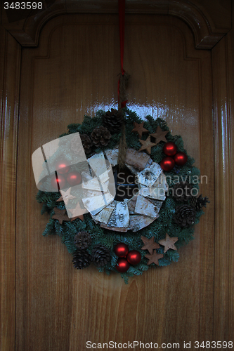 Image of Classic christmas wreath with decorations on a door