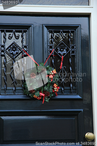 Image of Classic christmas wreath with decorations on a door