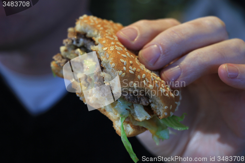 Image of Man holding a hamburger