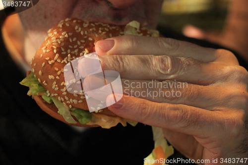 Image of Man holding a hamburger