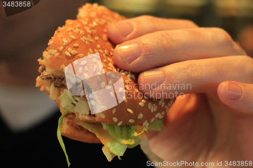 Image of Man holding a hamburger