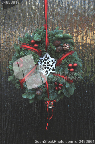 Image of Classic christmas wreath with decorations on a door