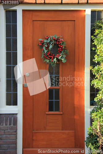 Image of Berry christmas wreath with decorations on a door