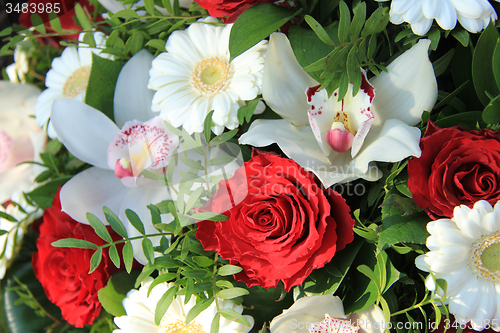 Image of Cymbidium orchids, red roses and white gerberas