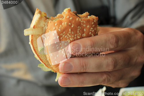 Image of Man holding a hamburger