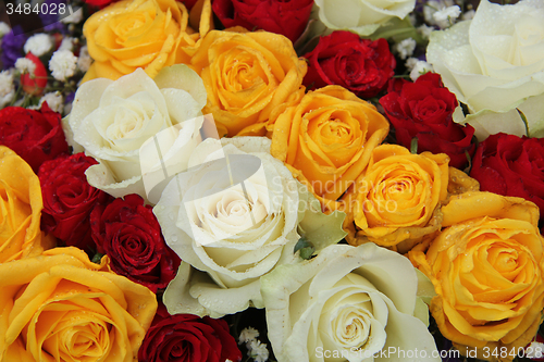 Image of yellow, white and red roses in a wedding arrangement