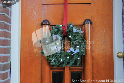 Image of Classic christmas wreath with decorations on a door