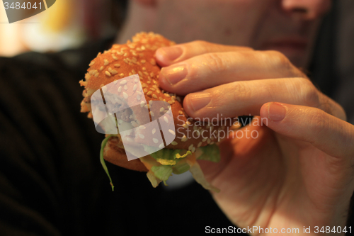 Image of Man holding a hamburger