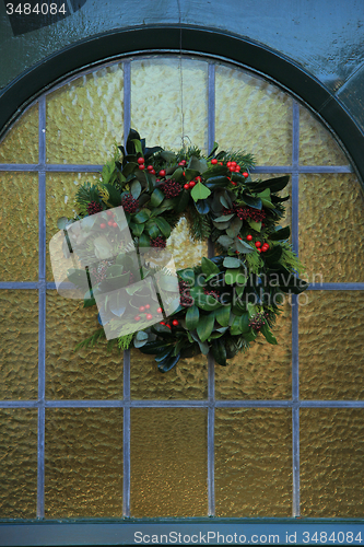 Image of Classic christmas wreath with decorations on a door